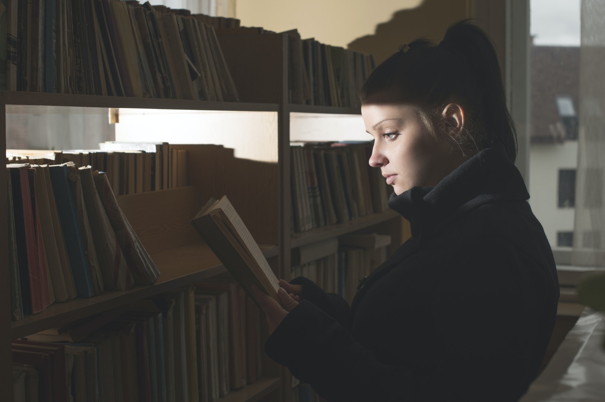 Female student reading book in a library