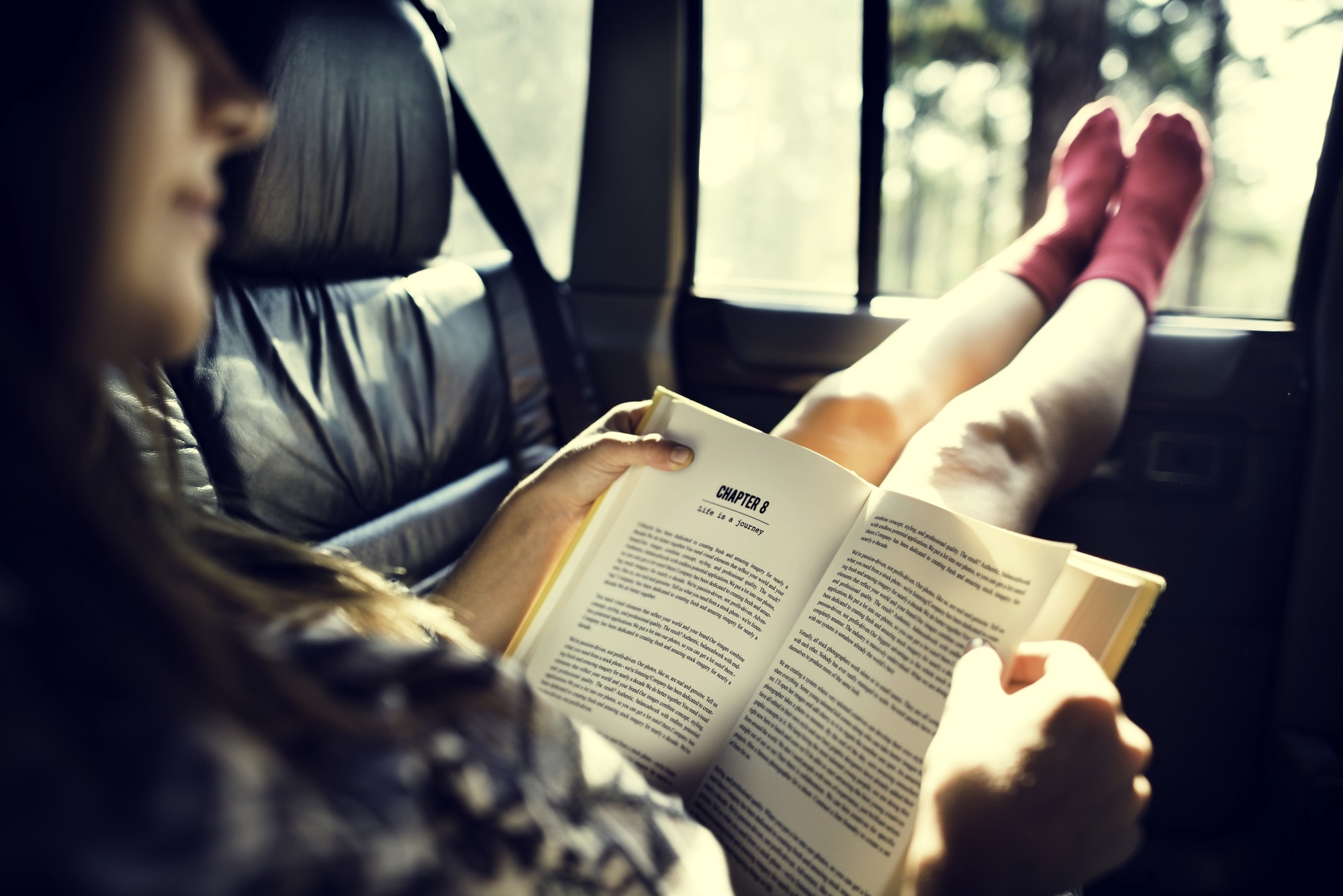 Girl Reading Book Inside Car Concept